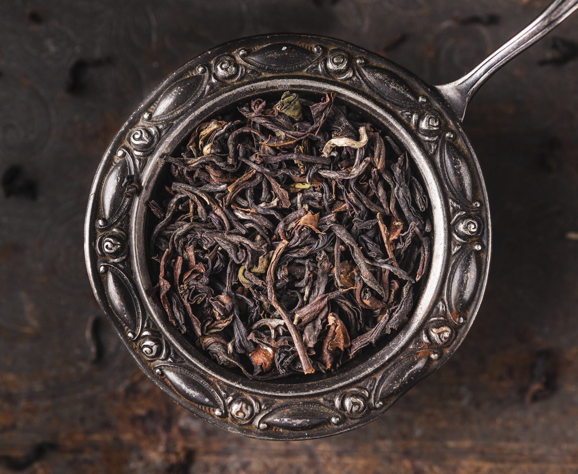 Loser Schwarzer Tee BIO Darjeeling SF Risheehat FTGFOP Kakra Musk mit rot-goldenen Blattspitzen auf goldenem Teller